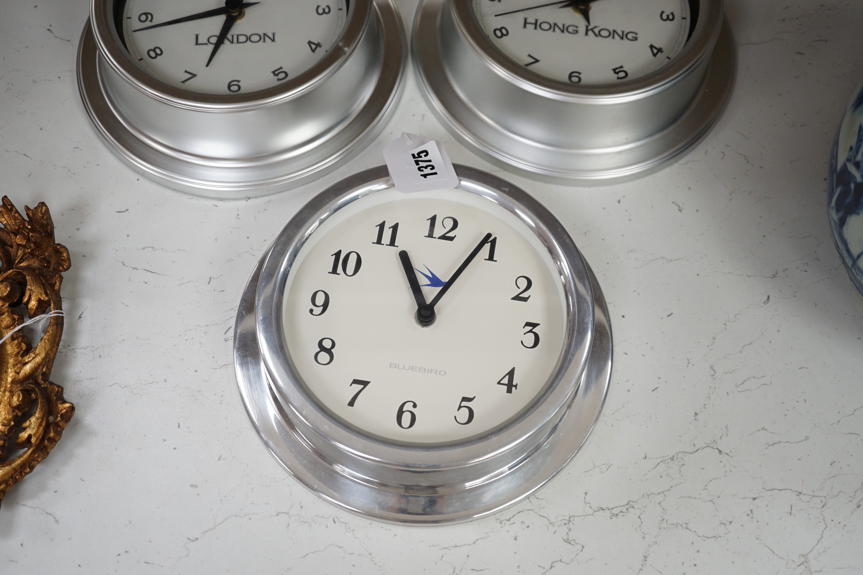 An Alessi wall clock and three similar smaller wall dials